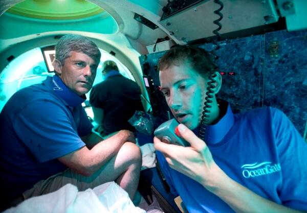 Submersible pilot Randy Holt, right, communicates with the support boat as he and Stockton Rush, left, CEO and Co-Founder of OceanGate, dive in the company's submersible, "Antipodes," about three miles off the coast of Fort Lauderdale, Florida, June 28, 2013. 